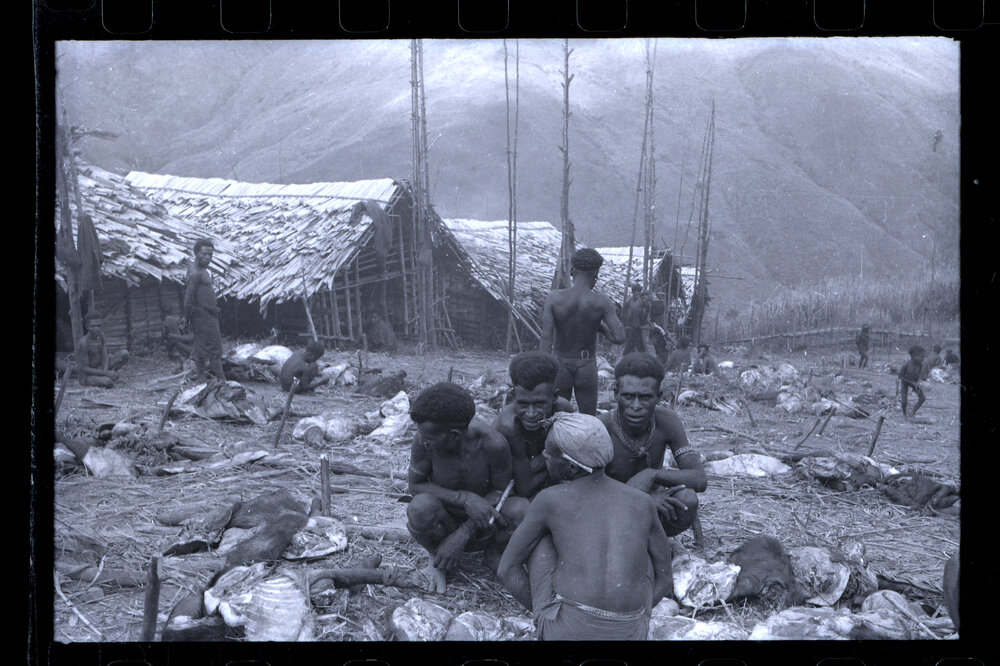 Men Sitting with Butchered Pigs