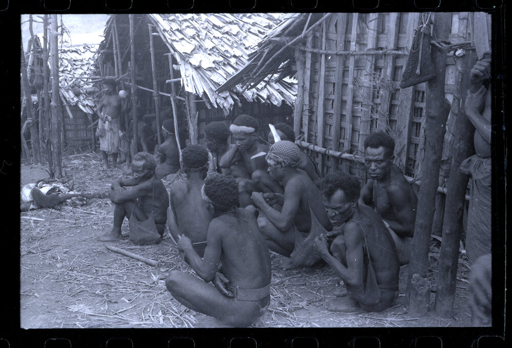 Group of Men Sitting Outside a Building