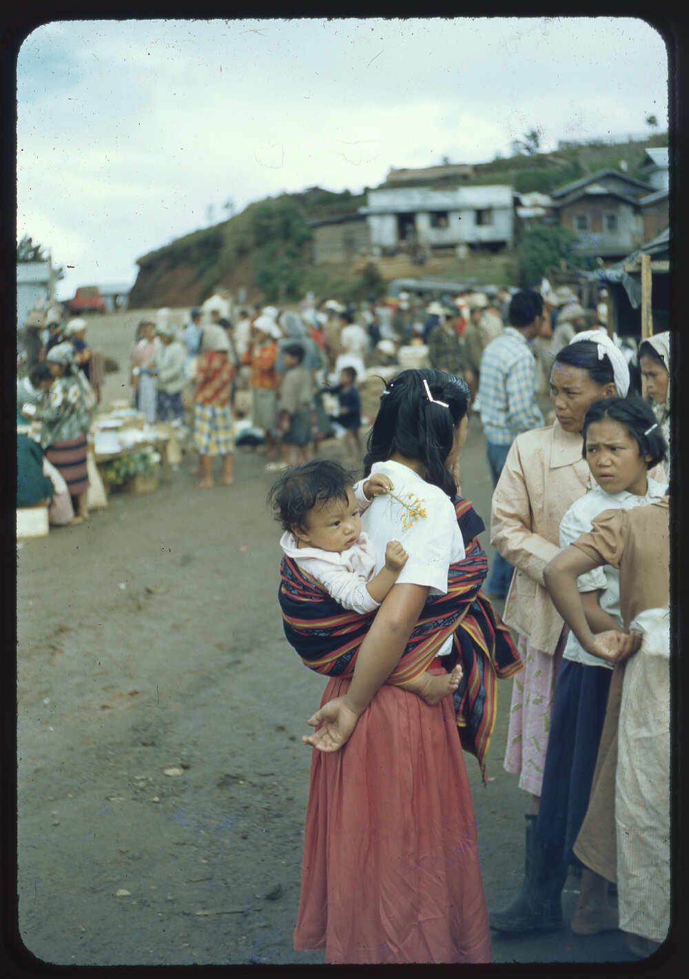 Woman Carrying Baby in a Market