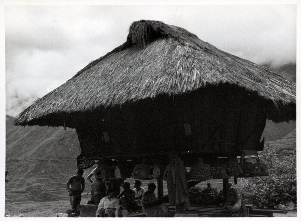 Group Sitting Beneath Wooden Structure on Stilts