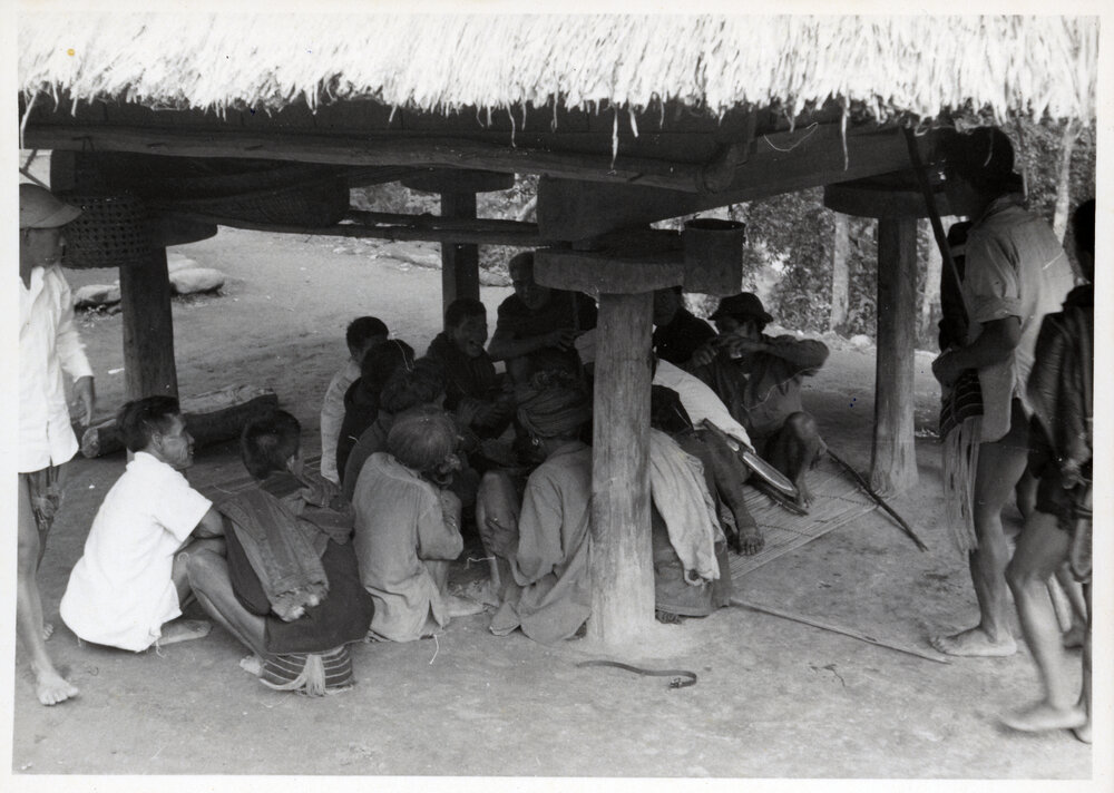 Group Sitting Beneath Wooden Structure on Stilts