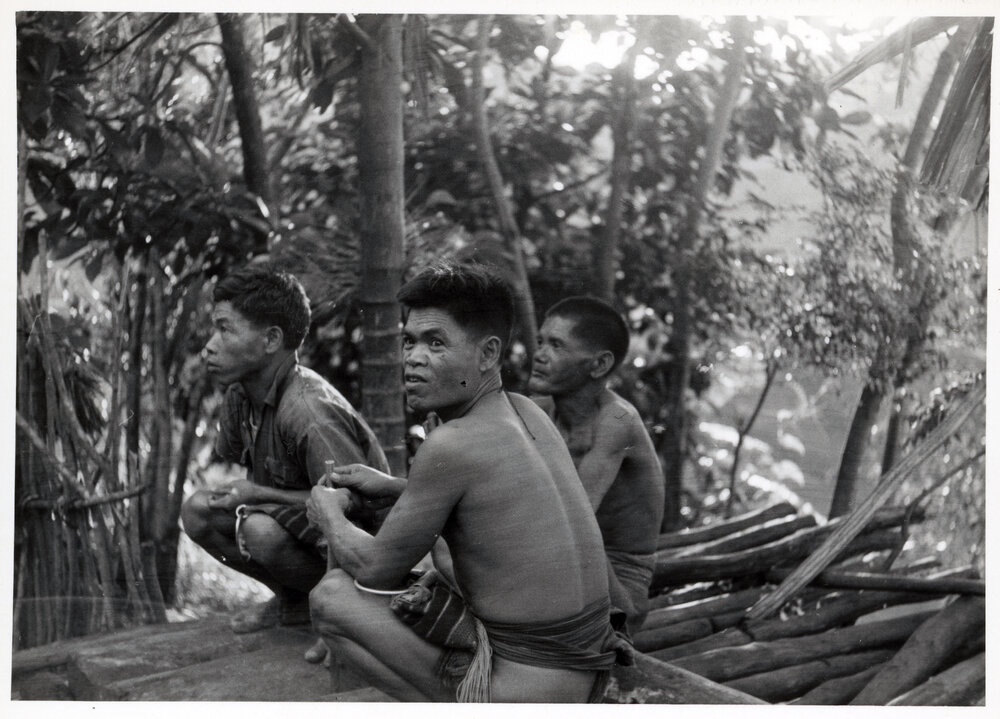 Three Men Sitting on Logs
