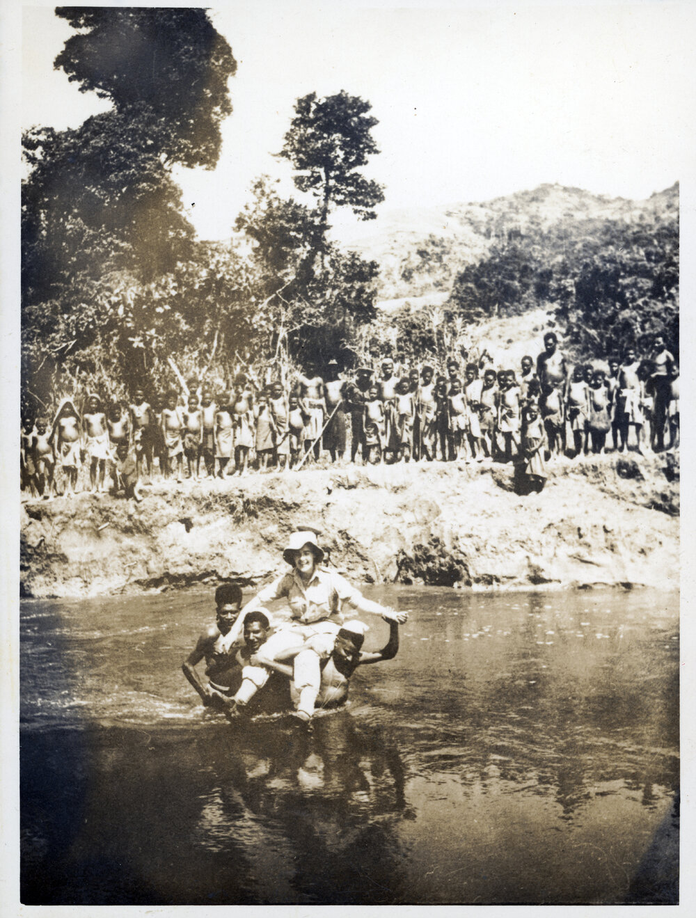 Woman Being Carried Across River, with Group Watching