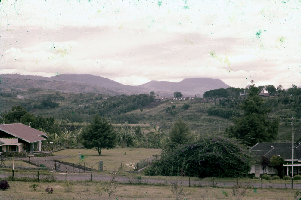 View Across Houses and Land, with Mountains in Background