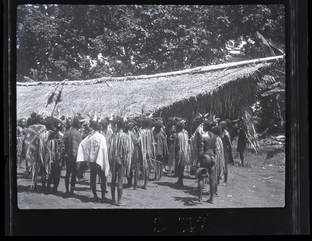 [Manum Island, New Guinea] Resting Between the Dances. The Men of Waia Chatting. The Men&rsquo;s Club House (&rsquo;Eda) in the Background. 