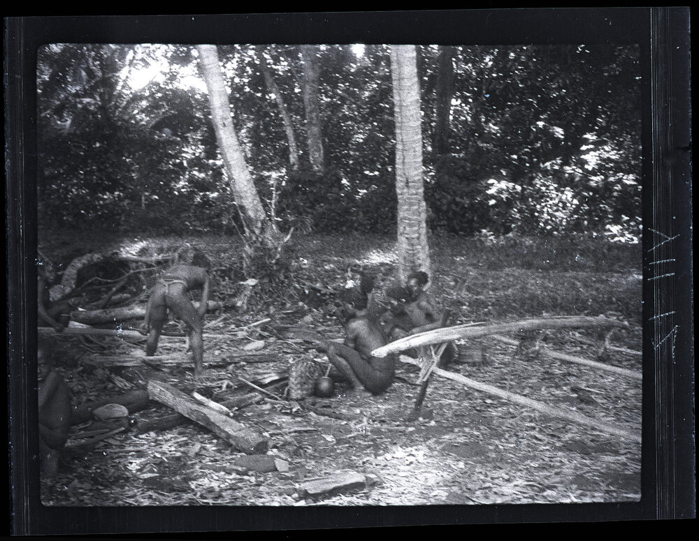[Manum Island, New Guinea] On the Beach After Getting Crabs. One Man is Shaping a Canoe Paddle.