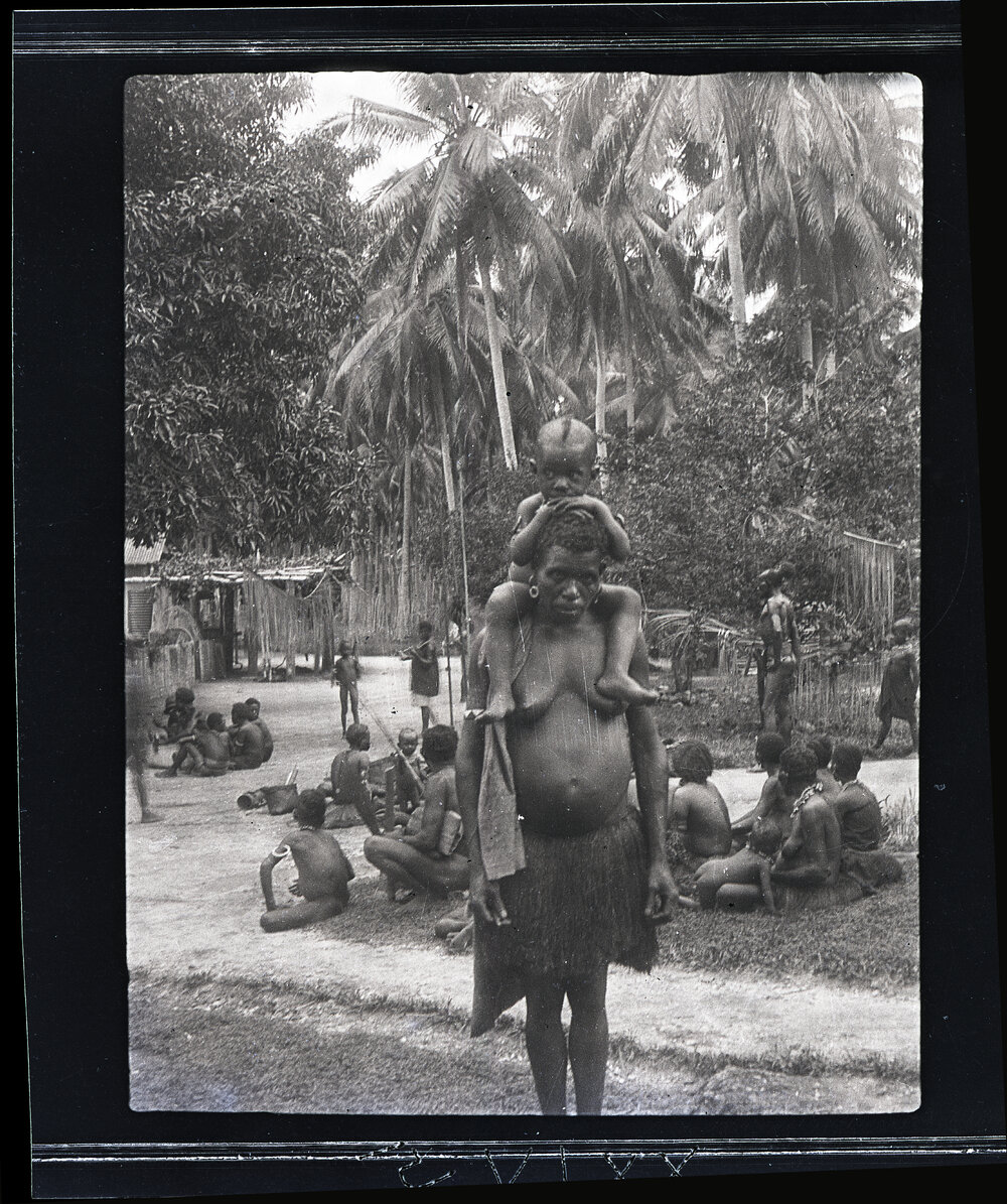[Manum Island, New Guinea] A Woman of Boroi with her Child on her Back