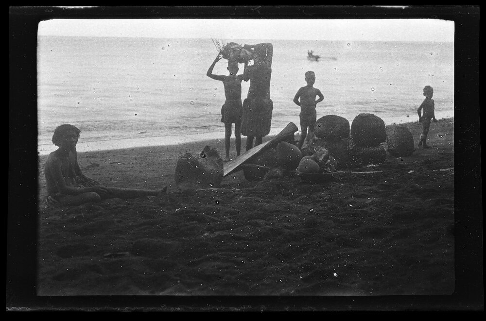 [Manum Island, New Guinea] Galip Nuts and Trays of Food in Leaf Bundles Waiting on the Beach to be Loaded onto the Canoes