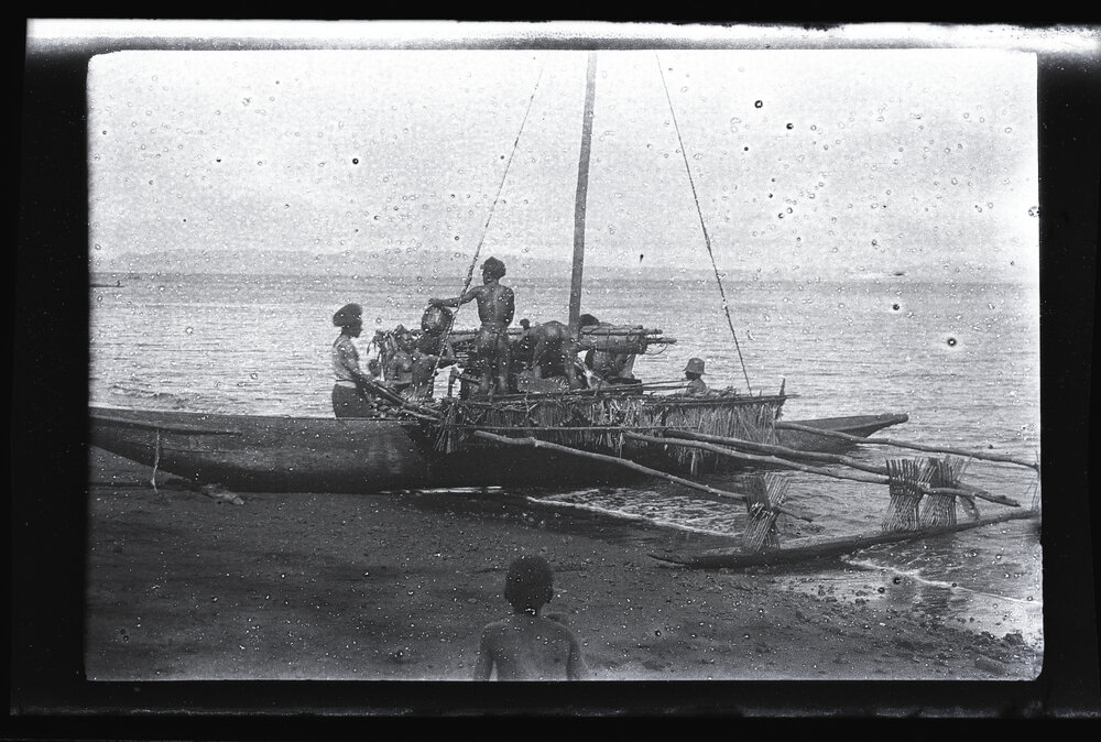 [Manum Island, New Guinea] Ladening up the Canoe with Baskets of Galips when the Canoe is Already Half in the Water