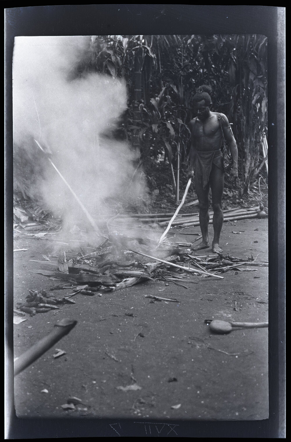 [Manum Island, New Guinea] Two Men Cooking Bananas etc in the Ashes of a Fire with which to Refresh the Workers