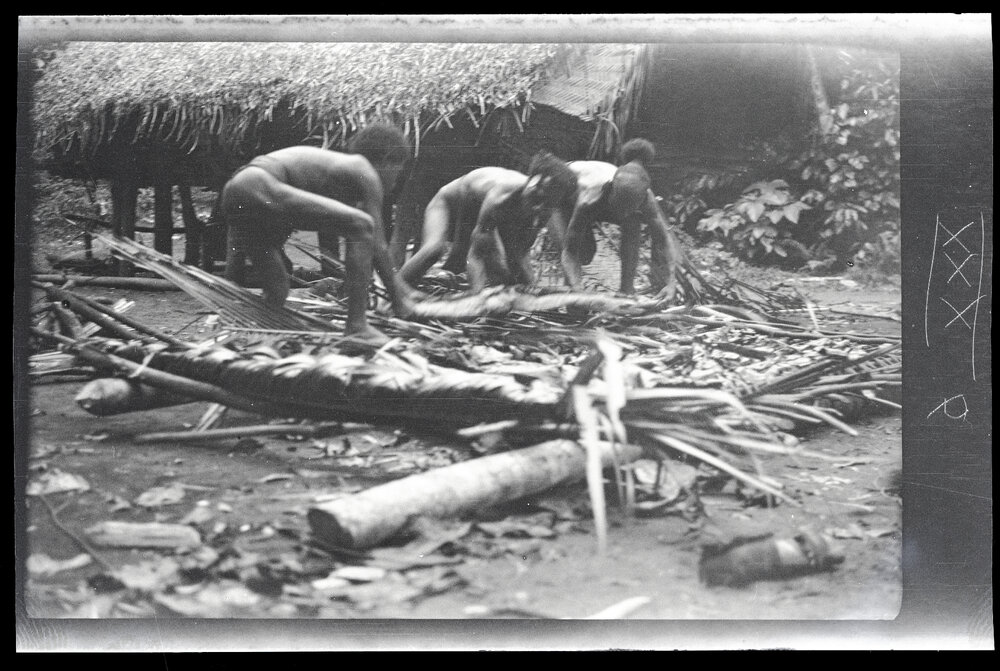 [Manum Island, New Guinea] Lifting one of the 'Cakes' of tapa'a 