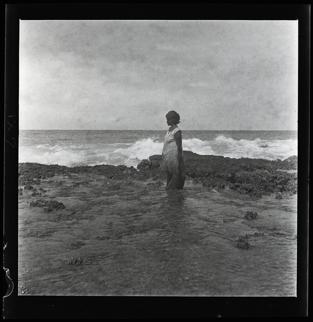 [Narau] A Woman Gathering Shellfish at the Edge of the Reef at Very Low Tide