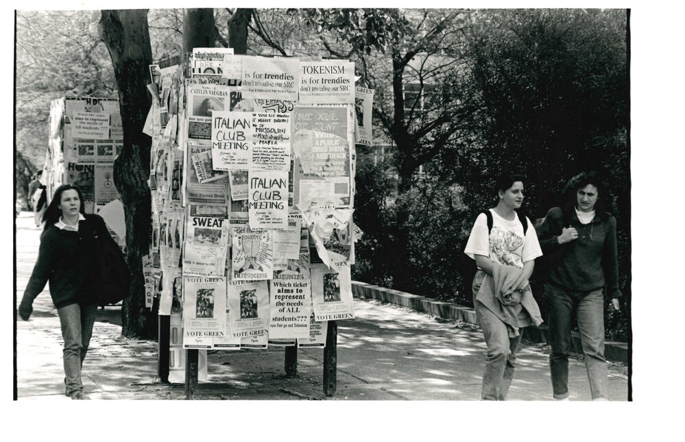 Students Walking Past Poster Boards