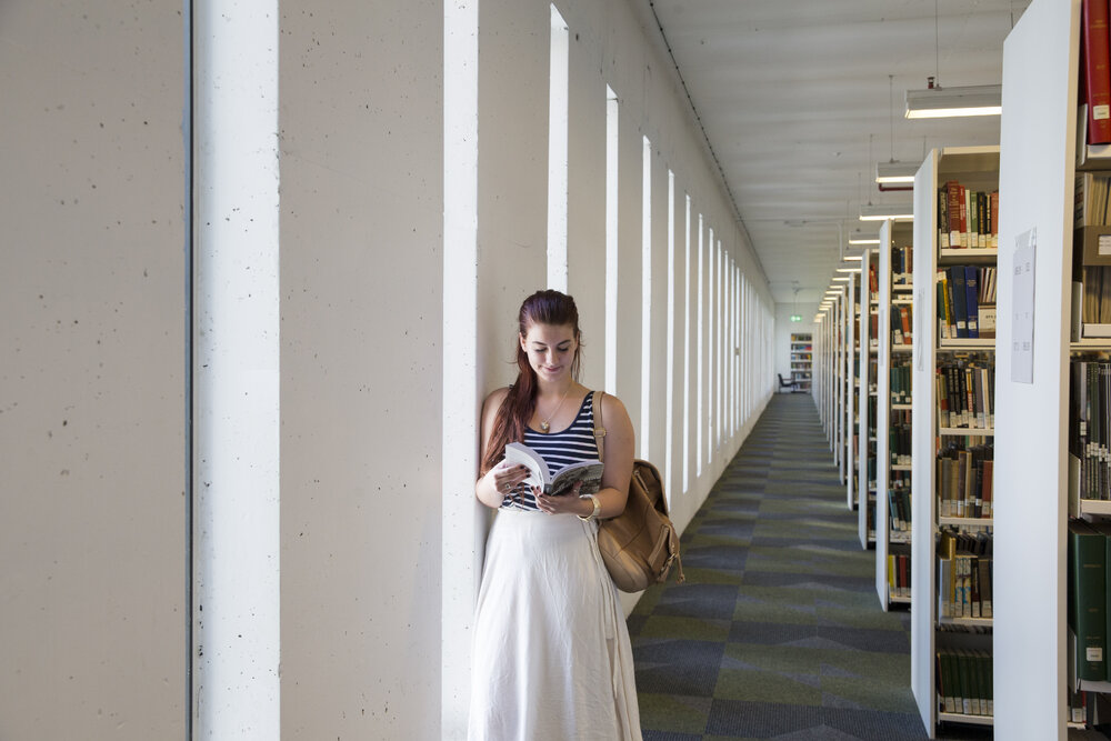 Student in Fisher Library Book Stack