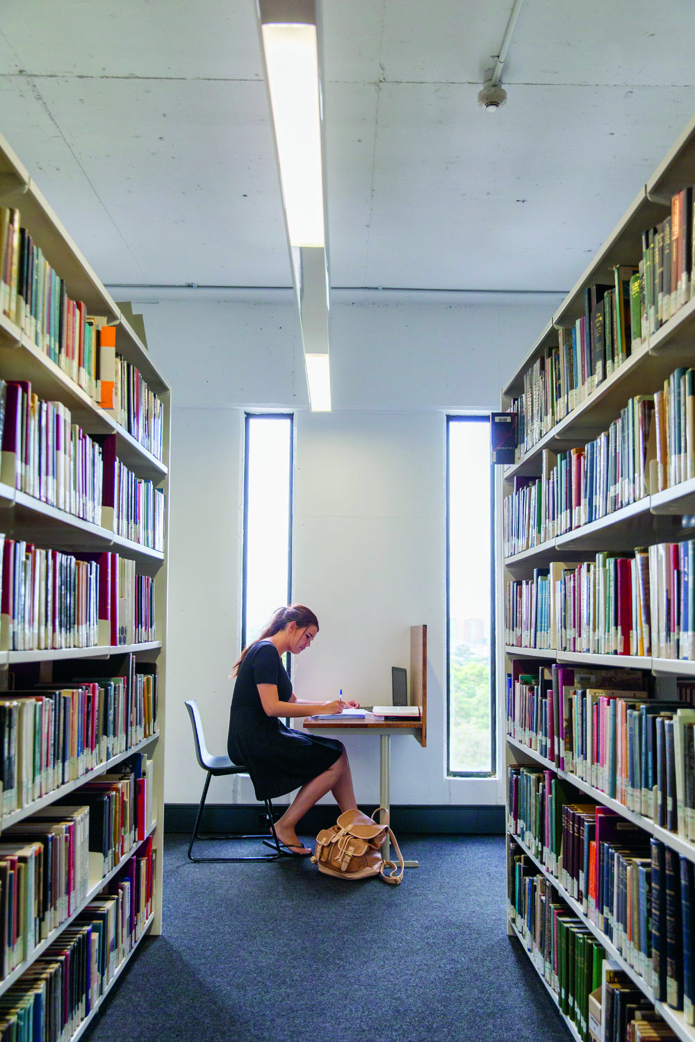 Student Studying in Fisher Library Book Stack