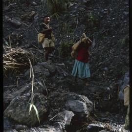 Two People Carrying Supplies