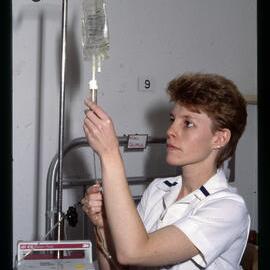 Nursing Student Adjusting Saline Drip 