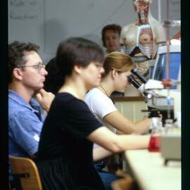 Medicine Students in Laboratory Using Microscopes