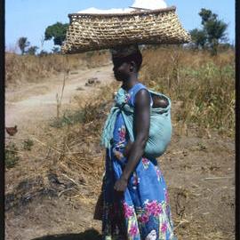 Woman Carrying Baby and Basket on her Head