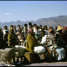 Seated Group with Schoolchildren Behind