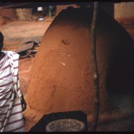 Person Next to Clay Oven
