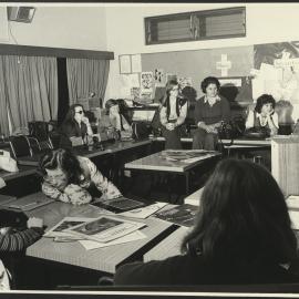 Nine Education Students in Class Room Sitting at and on Tables