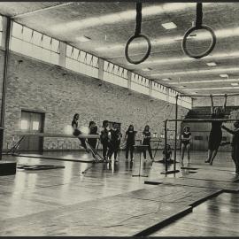 A Student Demonstrating an Exercise at Parallel Bars During a Gymnastics Class in the Gymnasium