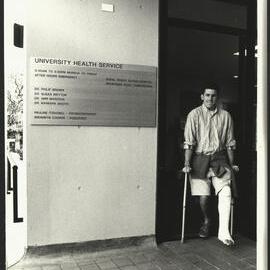 A Patient on Crutches with His Left Leg in Plaster Is Exiting the University Health Service