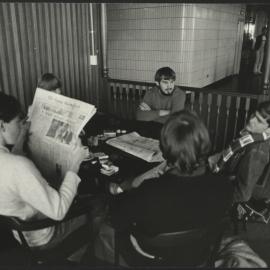 Students at a Round Table Chatting and Reading the Paper in the Wentworth Building
