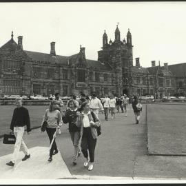 Students Crossing the Front Lawn Towards Fisher Library - Cars Parked in Front of Main Building