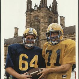 Two Students in Grid Iron Uniforms on the Front Lawn During Orientation/O-Week 1999