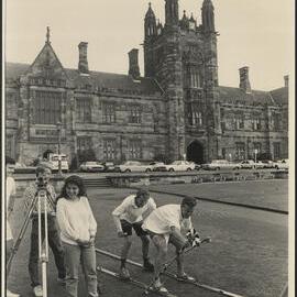 Surveying Students on Front Lawn with Two Students Pretending to Ski Using Their Measurements