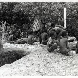 Group Sitting Near Grave