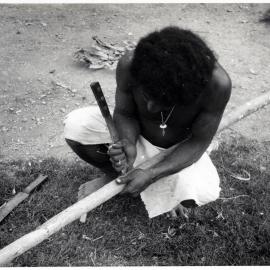 Man Stripping Bark from Log