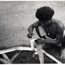 Man Stripping Bark from Log