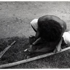 Man Stripping Bark from Log