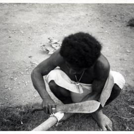Man Stripping Bark from Log
