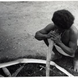 Man Stripping Bark from Log