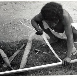 Man Stripping Bark from Log
