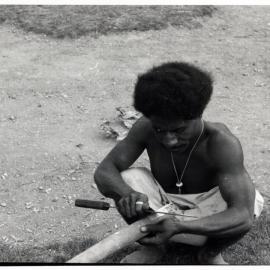 Man Stripping Bark from Log