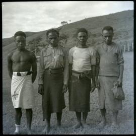 Four Men, One With Cross Sewn on Clothing