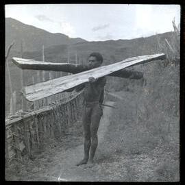 Man Holding Two Large Pieces of Wood