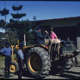 Margaret McArthur on Tractor with Uniformed Men