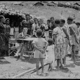 Group Gathered Around Man at Desk