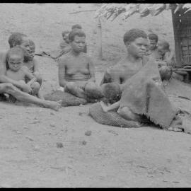 Women and Children Sitting Outside a Building