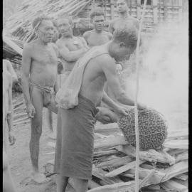 Placing Pandanus Nut on Fire
