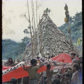 Group Suspending Cloth Through Village