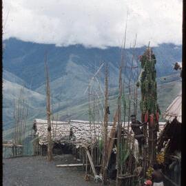 Group of Men Sitting at the Base of a Food Pole