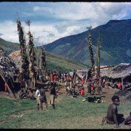 Groups Gathered in Front of Buildings and Food Poles