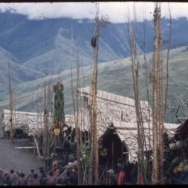 Group of Men Sitting at the Base of a Food Pole